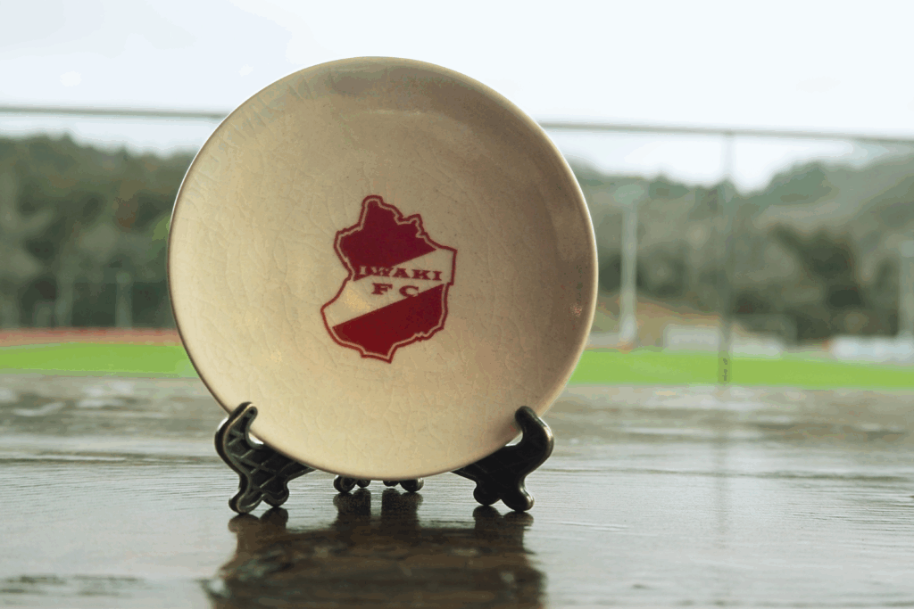 An Ohbori Soma ware small plate featuring the Iwaki FC emblem design.